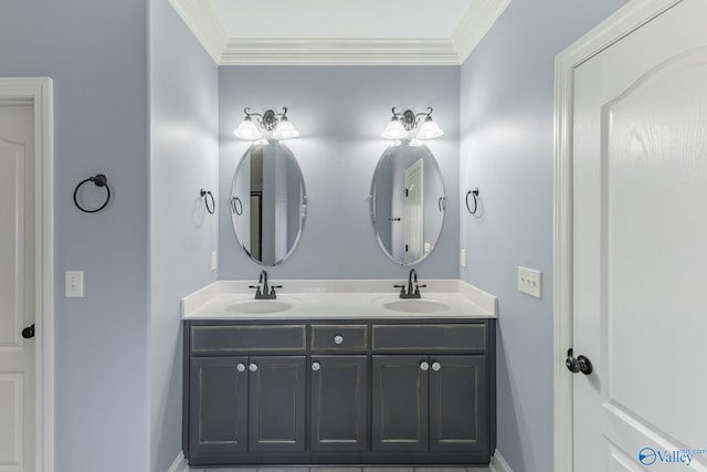 bathroom featuring crown molding, double vanity, baseboards, and a sink