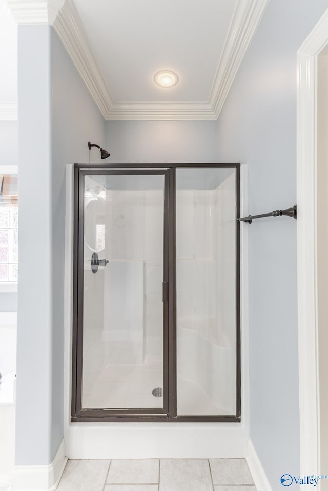 bathroom featuring tile patterned flooring, a shower stall, and crown molding