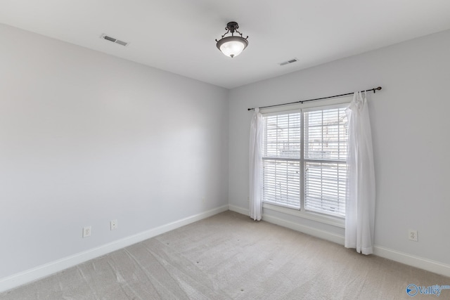 carpeted empty room with baseboards and visible vents