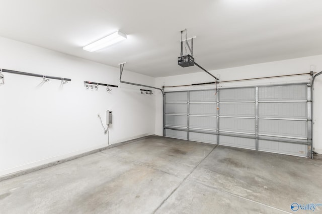 garage featuring a garage door opener and baseboards