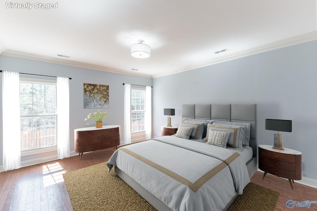 bedroom with visible vents, multiple windows, wood finished floors, and ornamental molding