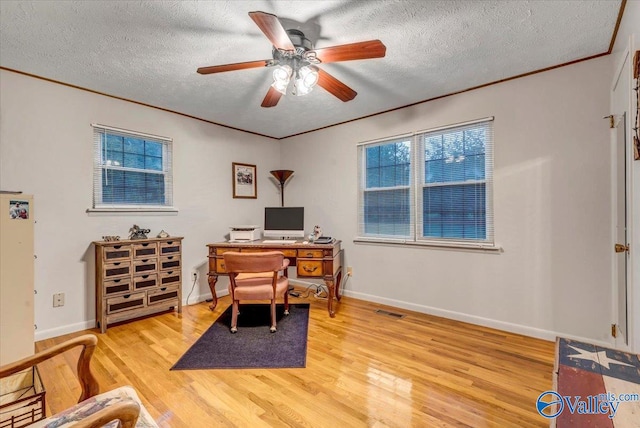 office space with ornamental molding, a textured ceiling, light wood-type flooring, and ceiling fan