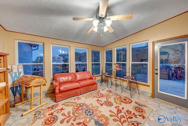 living room featuring ceiling fan, a textured ceiling, and vaulted ceiling