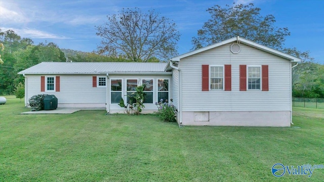 rear view of property with a yard