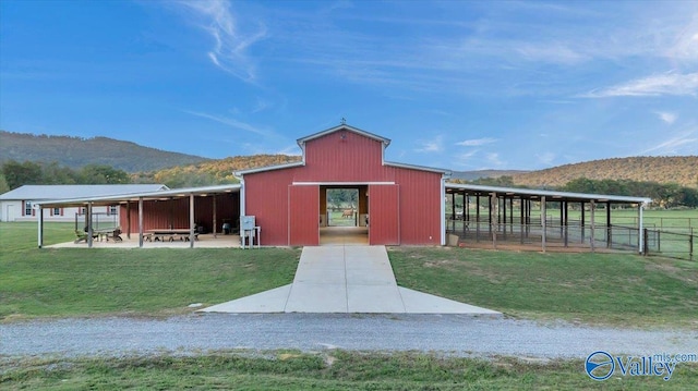 view of outdoor structure with a yard and a mountain view