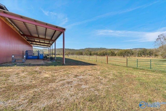 view of yard with a rural view and an outdoor structure