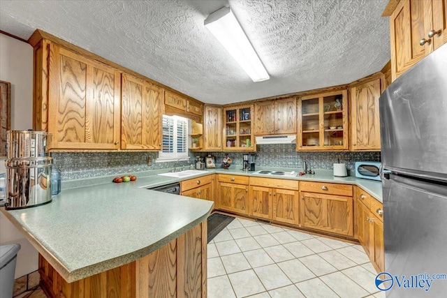 kitchen with white appliances, sink, a textured ceiling, kitchen peninsula, and decorative backsplash