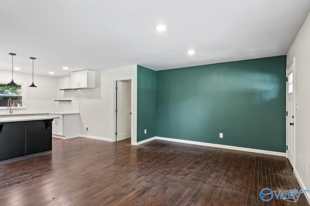 unfurnished living room featuring dark hardwood / wood-style flooring and sink