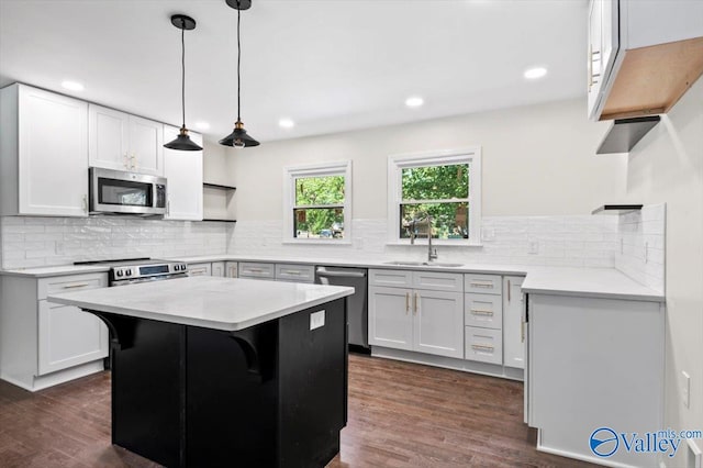 kitchen featuring a center island, stainless steel appliances, white cabinetry, and sink