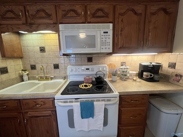 kitchen featuring sink, white appliances, and decorative backsplash