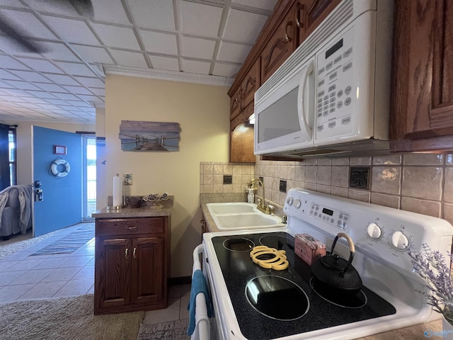 kitchen featuring light tile patterned flooring, sink, white appliances, and decorative backsplash