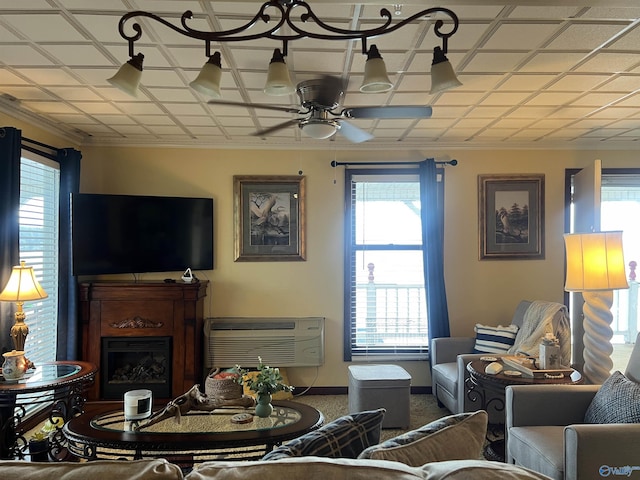 living room featuring crown molding, ceiling fan, and a wall unit AC