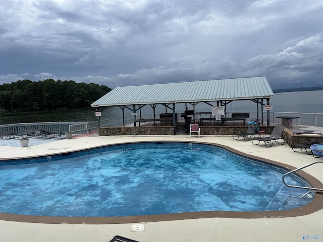 view of swimming pool with a patio and a water view