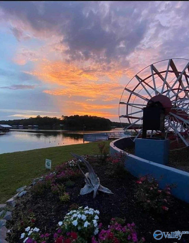 yard at dusk featuring a water view