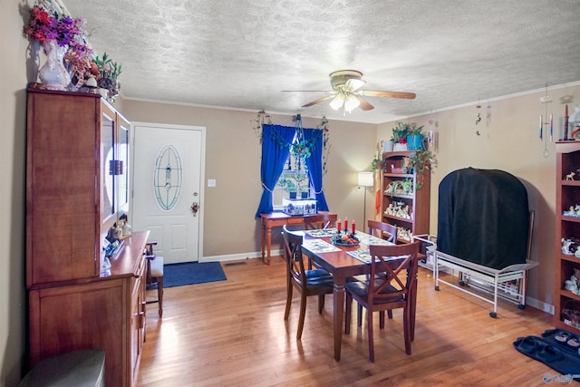 dining room with a textured ceiling, hardwood / wood-style flooring, ceiling fan, and ornamental molding