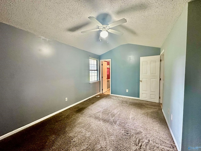 unfurnished bedroom with a textured ceiling, carpet flooring, vaulted ceiling, and ceiling fan