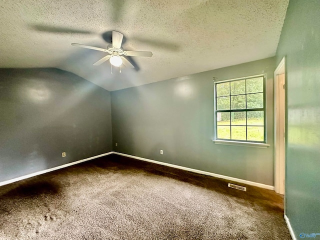 spare room with ceiling fan, a textured ceiling, lofted ceiling, and carpet