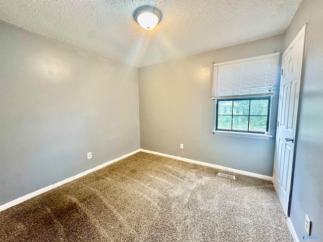 spare room with a textured ceiling and carpet floors