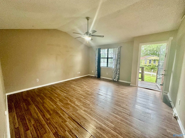 empty room featuring wood-type flooring, a textured ceiling, vaulted ceiling, and ceiling fan