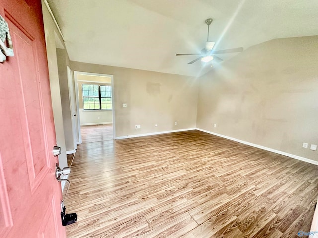 spare room featuring vaulted ceiling, light hardwood / wood-style floors, and ceiling fan