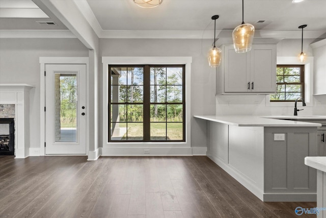 kitchen featuring a fireplace, dark hardwood / wood-style flooring, sink, and hanging light fixtures