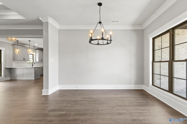 unfurnished dining area with crown molding, hardwood / wood-style floors, sink, and an inviting chandelier