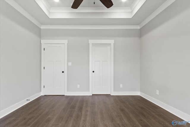 unfurnished bedroom with ceiling fan, a tray ceiling, and wood-type flooring