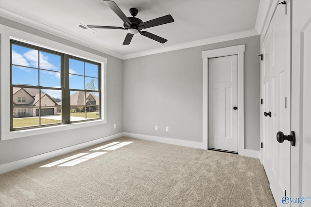 unfurnished bedroom with carpet floors, ornamental molding, and ceiling fan