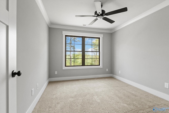 empty room featuring carpet floors, crown molding, and ceiling fan