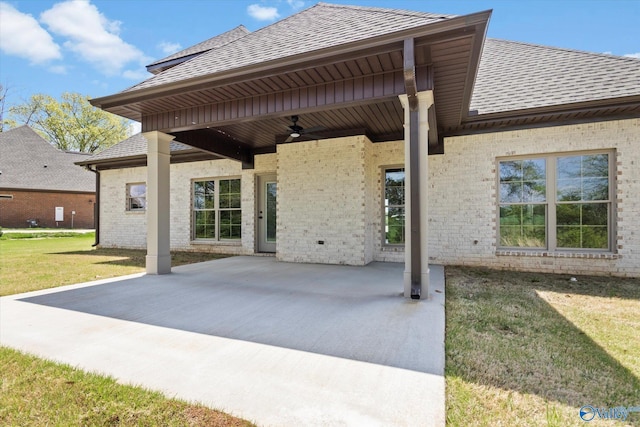 rear view of property with ceiling fan, a yard, and a patio area