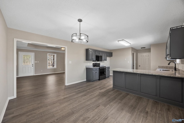 kitchen with electric range oven, light stone countertops, dark wood-type flooring, sink, and gray cabinetry