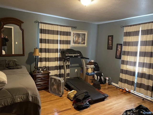 bedroom featuring wood-type flooring and a textured ceiling