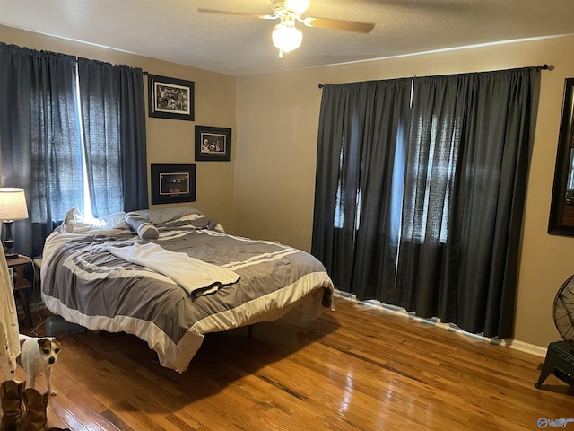 bedroom featuring hardwood / wood-style floors, a textured ceiling, and ceiling fan