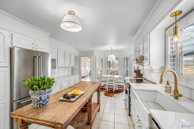 kitchen featuring premium appliances, decorative backsplash, and white cabinets