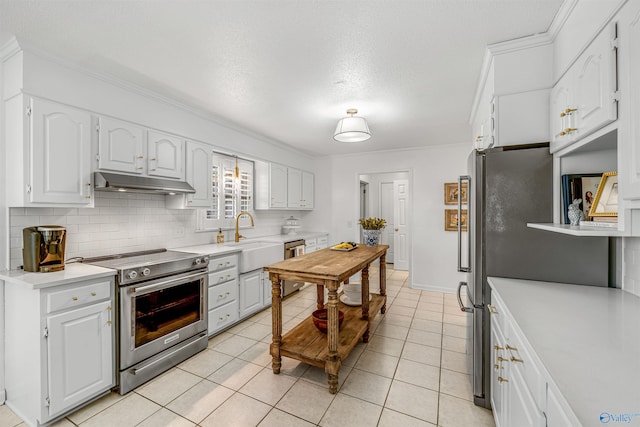 kitchen with stainless steel appliances, sink, light tile patterned floors, and white cabinets