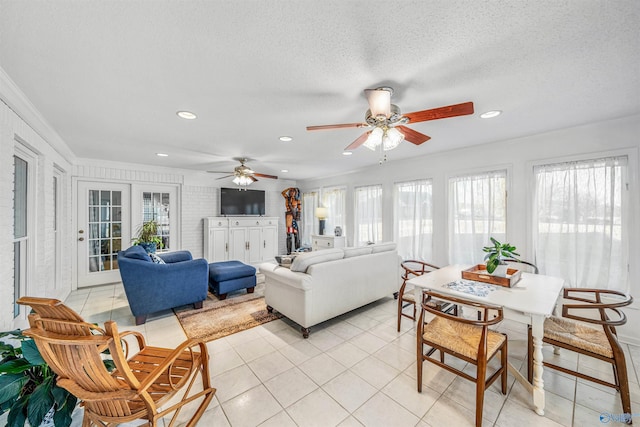 living room featuring ornamental molding, light tile patterned floors, and a textured ceiling