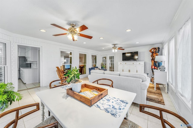 dining room featuring crown molding, brick wall, and light tile patterned floors