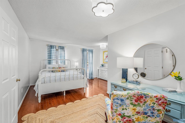 bedroom with wood-type flooring and a textured ceiling