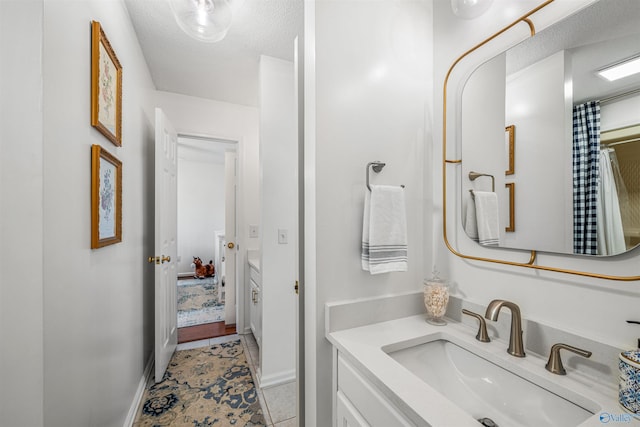 bathroom featuring tile patterned flooring, vanity, and a textured ceiling