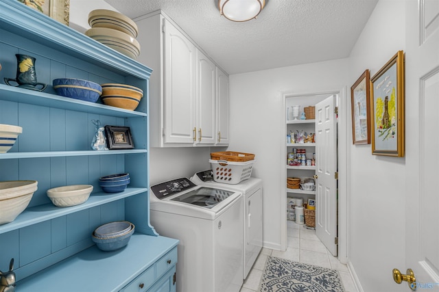 laundry room with cabinets, a textured ceiling, washer and dryer, and light tile patterned floors