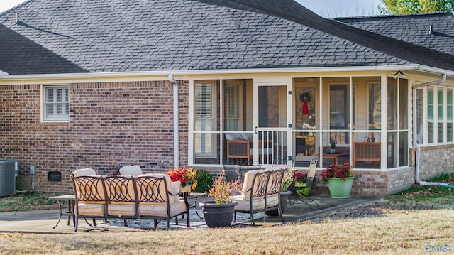 rear view of house featuring an outdoor living space, a patio, a sunroom, and central AC