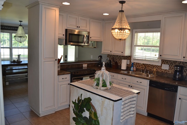 kitchen featuring sink, white cabinetry, hanging light fixtures, and appliances with stainless steel finishes