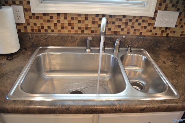 room details with sink, backsplash, and white cabinetry