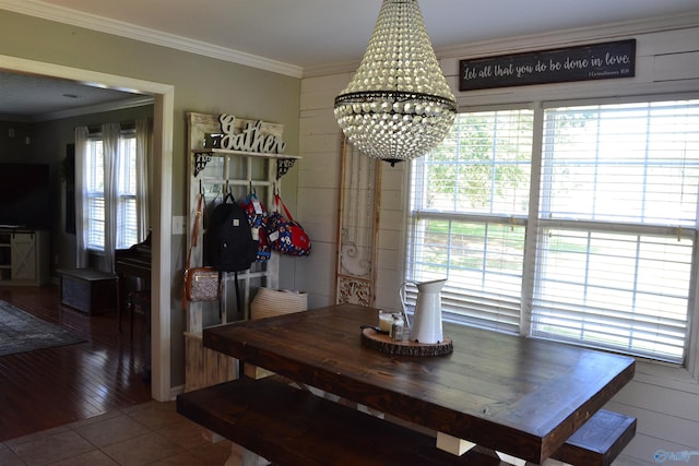 dining space with an inviting chandelier, tile patterned floors, and ornamental molding