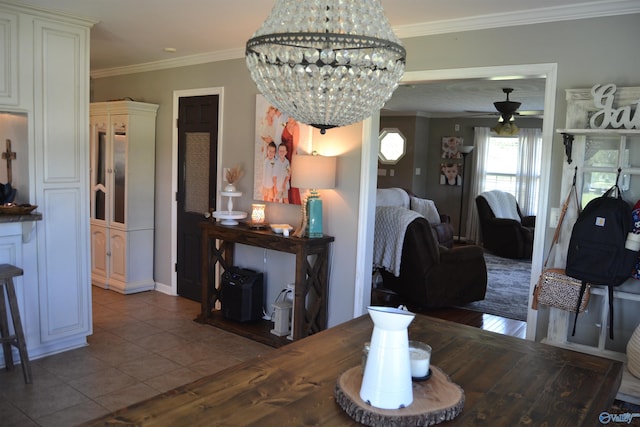 dining room with tile patterned floors, ceiling fan with notable chandelier, and ornamental molding