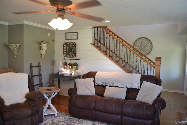 living room featuring ceiling fan, ornamental molding, a textured ceiling, and wood-type flooring