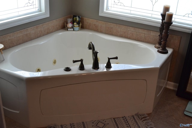 bathroom with a bath and tile patterned flooring