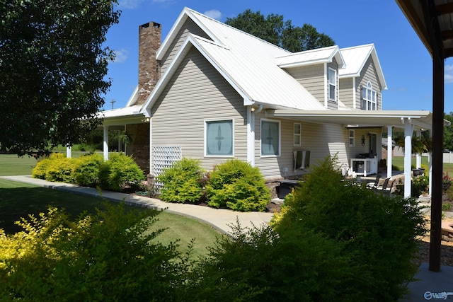 view of property exterior with covered porch and a lawn