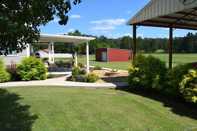 view of yard featuring an outbuilding, a garage, an outdoor fire pit, a gazebo, and a patio area