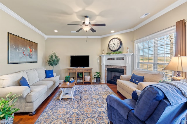 living room with a fireplace, visible vents, baseboards, dark wood-style floors, and crown molding